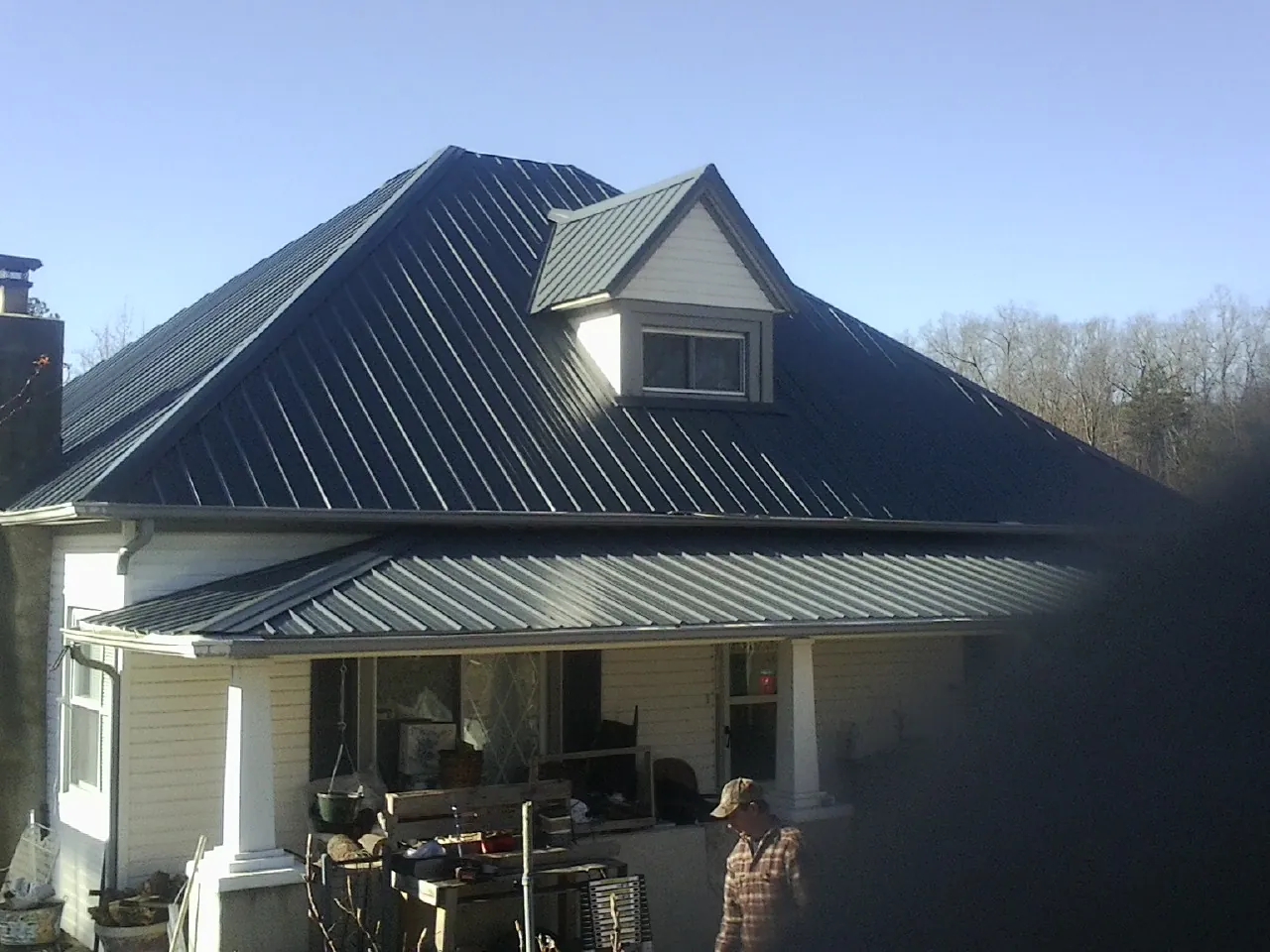 Dark blue standing seam metal roof with a dormer above a front porch in Murrells Inlet