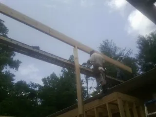 Carpenter setting a ridge beam over a new addition frame — Ice Dam Removal by Roofing Brothers in Murrells Inlet