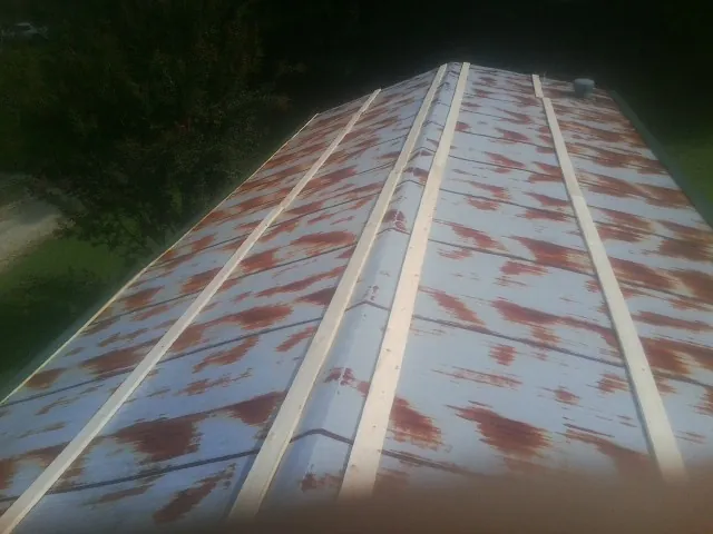 Rusted metal roof panels with new wood purlins before replacement — Storm Damage Roof Repair in Murrells Inlet by Roofing Brothers