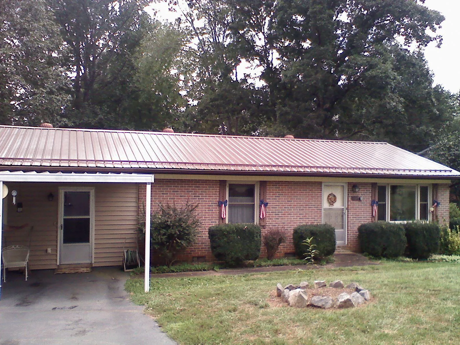 Bronze metal roof and carport on a brick ranch home — Roof Repair work by our crew in Murrells Inlet