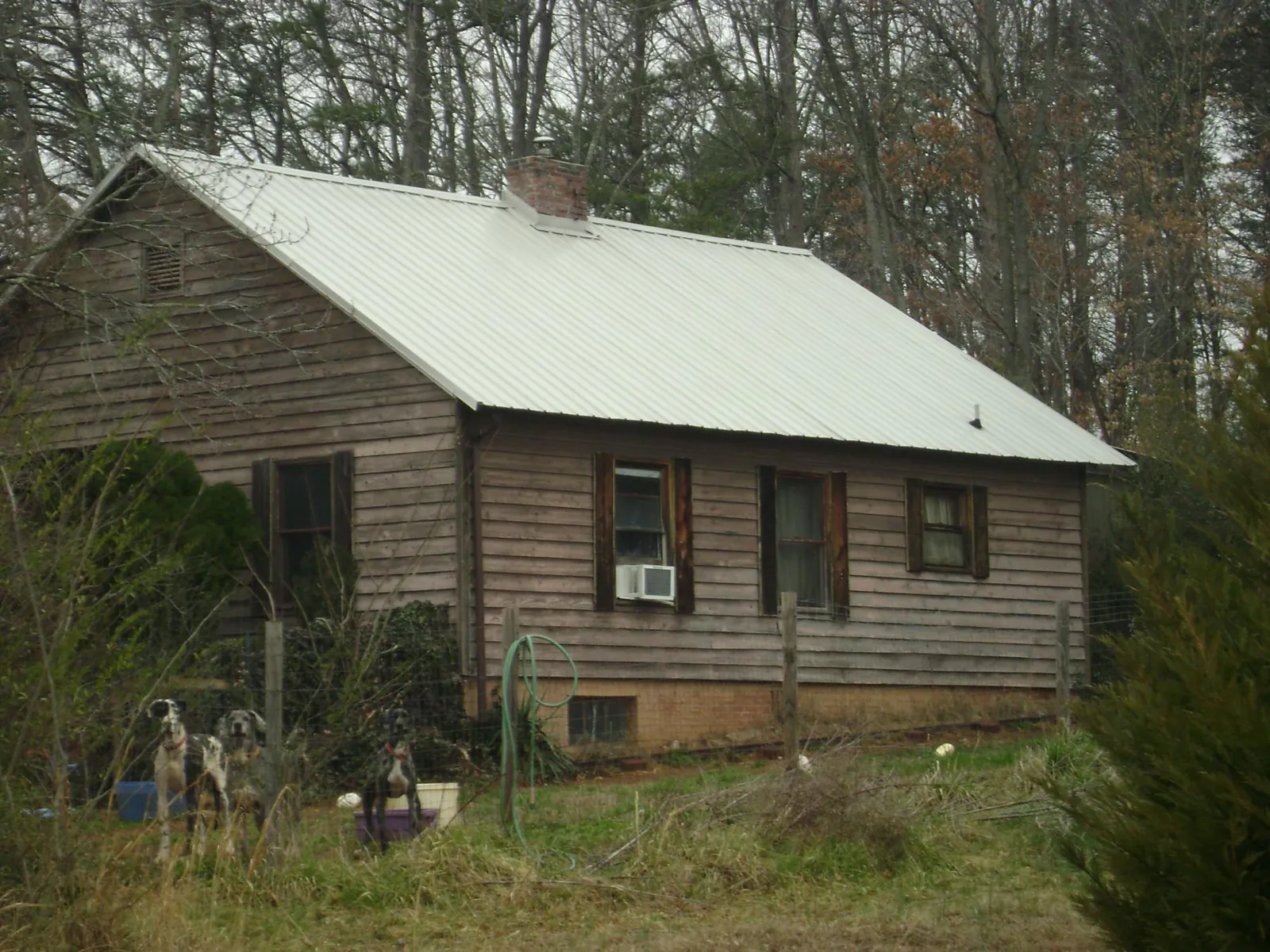 White metal roof on an old wood sided farmhouse, from a Metal Roof Installation job in Murrells Inlet